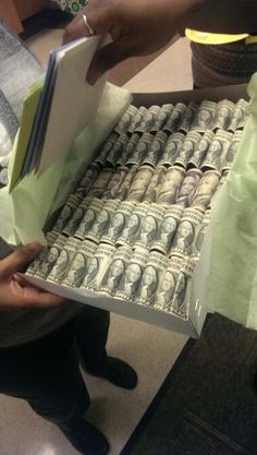 a person holding a box full of money