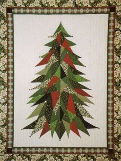 a quilted christmas tree is hanging on the wall