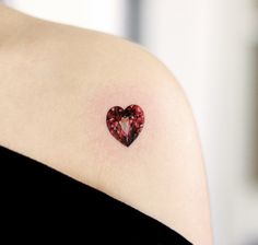 a woman with a heart tattoo on her shoulder