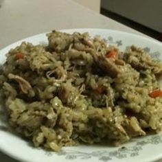 a white plate topped with rice covered in meat and carrots on top of a table