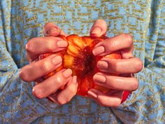 a woman holding an apple in her hands with both hands on the top of it