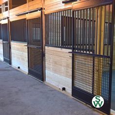 the inside of a horse stable with wooden walls and bars on each side, along with sliding doors