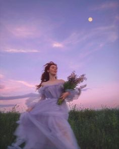 a woman in a dress is walking through the grass