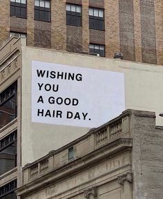 a sign on the side of a building that says wishing you a good hair day