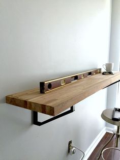 a wooden shelf sitting on top of a white wall