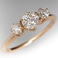 three stone diamond ring in yellow gold with white diamonds on the sides and center stones