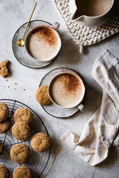 two cups of coffee and some cookies on a table