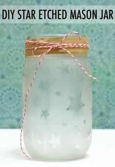 a mason jar filled with homemade diy star etched mason jars and twine on top