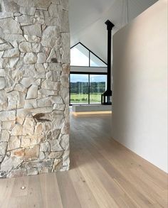 an empty room with wood floors and stone walls