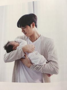 a man holding a baby in his arms