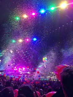 a large group of people at a concert with confetti in the air