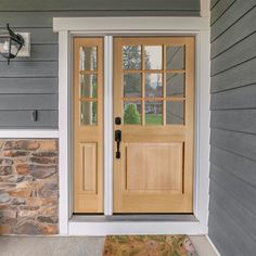 two wooden doors on the side of a house