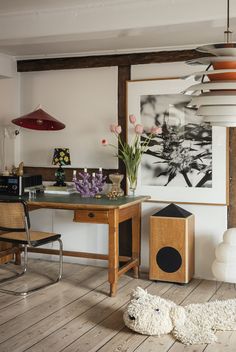 a room with a desk, chair and pictures on the wall above it is shown