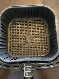 a metal grate sitting on top of a wooden table next to a black object