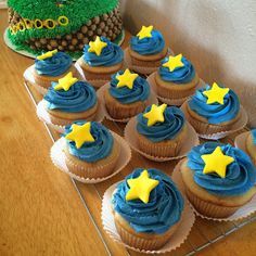 cupcakes with blue frosting and yellow stars on them sitting on a table