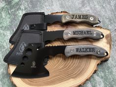 three knives sitting on top of a piece of wood with the names james and michael walker engraved on them