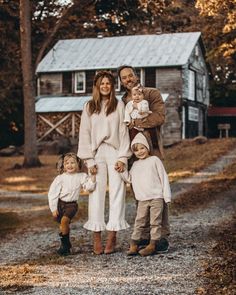 a family posing for a photo in front of a barn