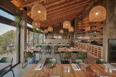 an empty restaurant with wooden tables and green chairs