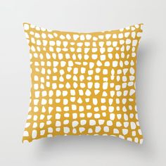 a yellow and white pillow with an abstract design