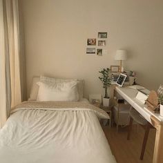 a white bed sitting next to a wooden desk