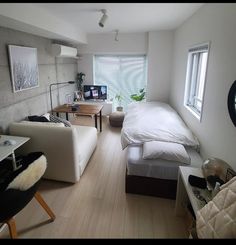 a bedroom with white walls and wood floors