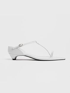 pieton is a modern-based shoe brand developed by imagining women in the city, and presents items that are not limited to seasons through slick shapes, minimal designs, and variations of various materials.- This is a toe-ring sandal- A T-strap that highlights the instep line- Very low height, with only the heel slightly hidden and the entire foot exposed- The low heel height allows for a stable fit White Sandals With Sculpted Heel And Single Toe Strap, Modern White Sandals With Single Toe Strap, Modern T-strap Sandals For Spring, White Toe Post Sandals For Evening, Modern White Sandals With Heel Loop, Modern White Sandals With Low Heel, Minimalist Single Toe Strap Sandals For Spring, Modern T-strap Sandals With Heel Loop, Modern T-strap Heels For Summer