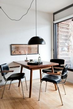 a dining room table and chairs in front of a window