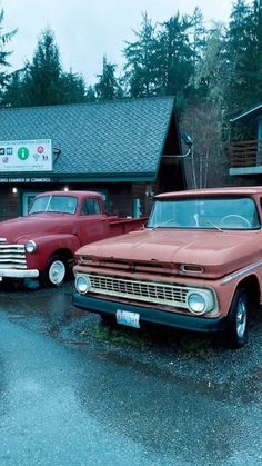 two old trucks parked in front of a building