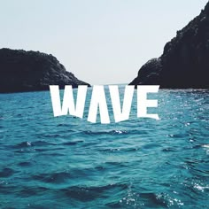 the word wave is floating in the middle of the water near some mountains and rocks