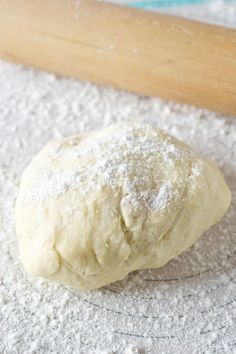 a ball of dough sitting on top of a floured surface next to a rolling pin