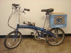 a blue bicycle parked next to a wall with a basket on the front and side