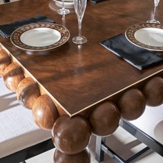 a wooden table with plates and wine glasses on it, along with other dining room furniture