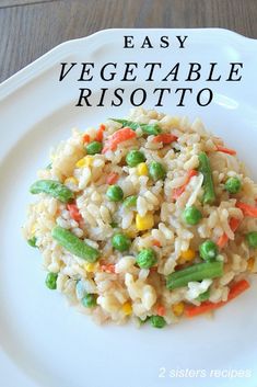 a white plate topped with rice and veggies on top of a wooden table