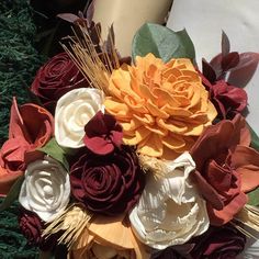 a bouquet of flowers sitting on top of a grass covered field next to a person