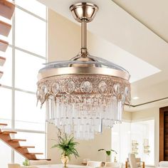 a chandelier hanging from the ceiling in a living room next to a staircase