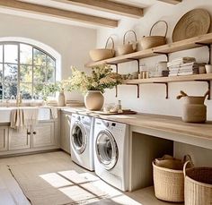 a washer and dryer in a room with open shelvings on the wall