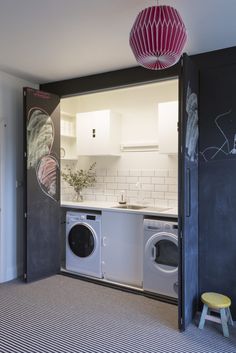 a washer and dryer in a room with a chalkboard wall behind it