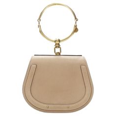 CHLOE Medium Nile gold bangle bracelet handle taupe leather saddle bag Reference: JACG/A00010 Brand: Chloe Model: Nile bag Material: Leather, Metal Color: Beige, Gold Pattern: Solid Closure: Magnet Lining: Suede Extra Details: Antique gold-tone hardware. Taupe leather and suede trim. Gold-tone flat studs. Chloe logo embossed at front face. Horse shoe saddle shape. Suede lining. Made in: Italy CONDITION: Condition: Very good, this item was pre-owned and is in very good condition. Please refer to Bag Reference, Chloe Logo, Leather Jewels, Louis Vuitton Limited Edition, Taupe Leather, Leather Saddle Bags, Front Face, Frame Bag, Horse Shoe