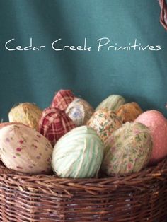 several balls of yarn in a basket with the words cedar creek primitives on it