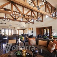 a living room filled with furniture and lots of wood beamed ceiling beams in an open concept home