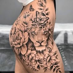 a woman's thigh with flowers and a lion on it