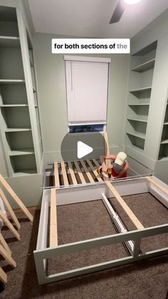 a bed frame being built in a room with bookshelves on the walls and shelves behind it