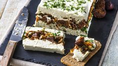 slices of cake sitting on top of a cutting board next to an olive and bread knife