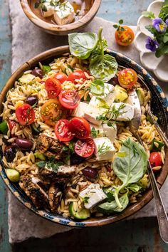 a bowl filled with pasta and vegetables on top of a table