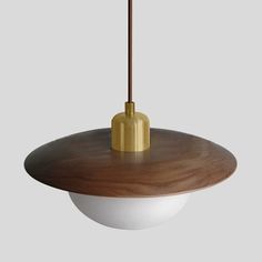 a wooden table with a white bowl underneath it and a light fixture hanging from the ceiling