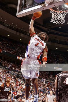 a basketball player dunking the ball into the hoop in front of an arena full of people