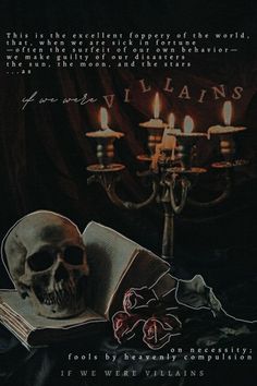 a skull sitting on top of an open book in front of a candelabra