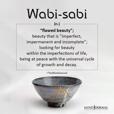 a black and white bowl with an orange star on it's side that says, wabi - sabi