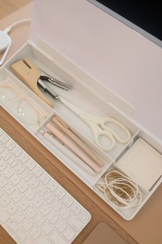 a computer keyboard sitting on top of a desk next to a mouse and other items