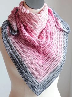 a mannequin wearing a pink and gray crocheted scarf on top of a white dummy